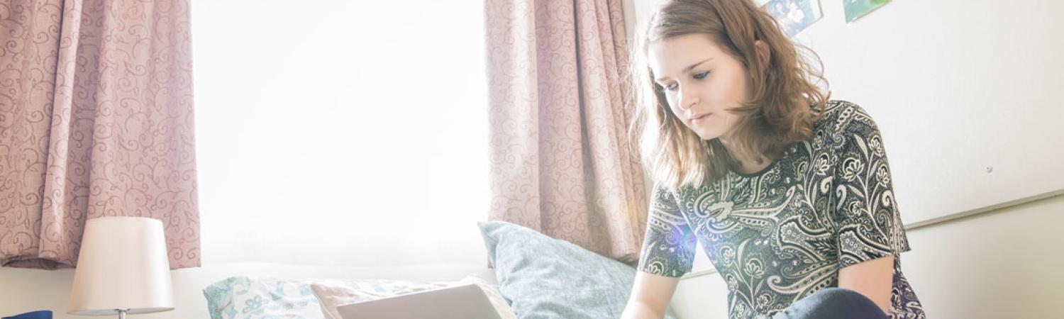 Student sat in International House accommodation room