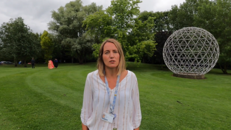 Charlotte Coleman standing near the Geodesic Dome by the lake