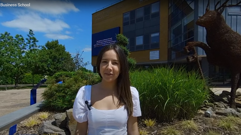 Student in front of Surrey Business School